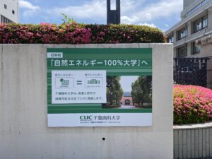 自然エネルギー100％大学へという校門の看板