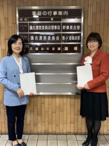 議会棟1階の案内板の前で伊藤ひとみと本西みつえが立っている写真